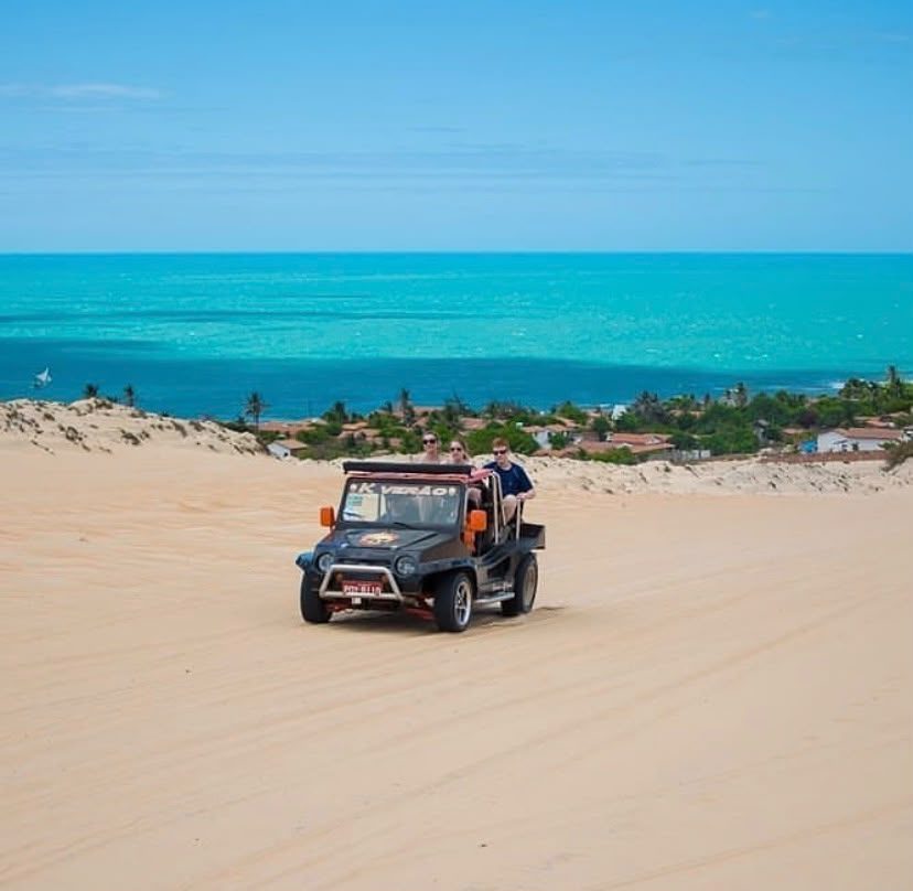 Buggy sobre as dunas brancas com o mar turquesa ao fundo